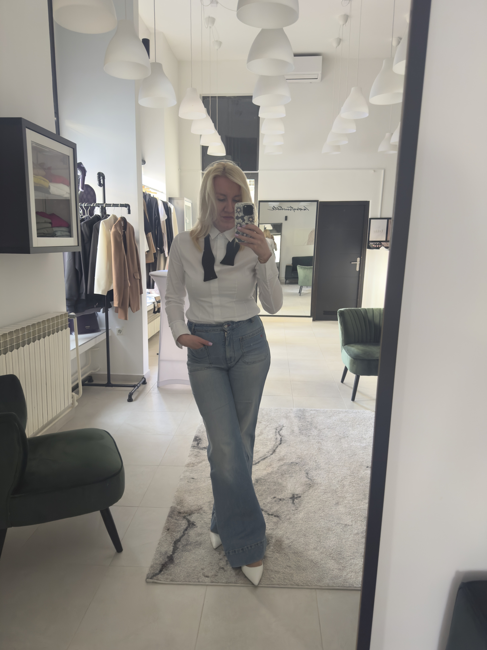 Žena u bijeloj košulji s crnom ženskom kravatom - detalj modela.
